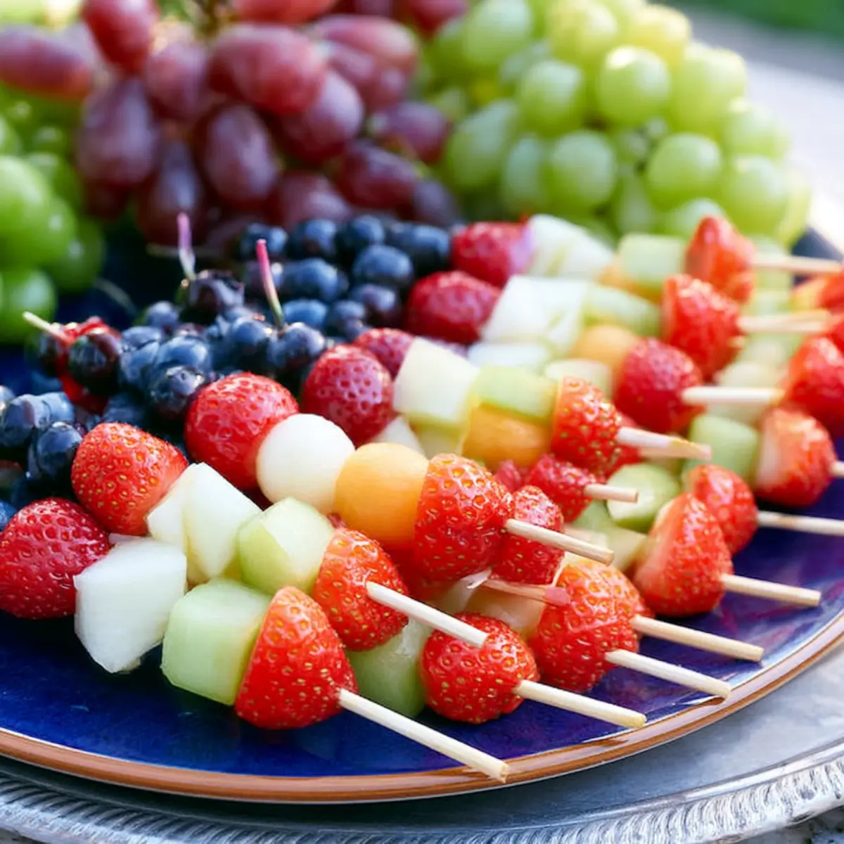 Obstspieße mit Melone, Erdbeeren, Trauben und Blaubeeren